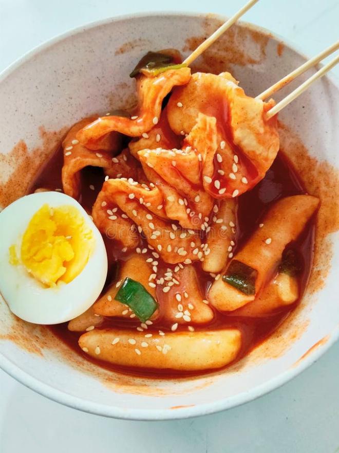 Cận cảnh đĩa bánh gạo cay Tteokbokki đỏ rực với chả cá và trứng luộc