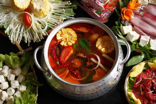 Nồi nước dùng lẩu đang sôi nhẹ với hương thơm từ sả và ớt đỏ rực rỡ
