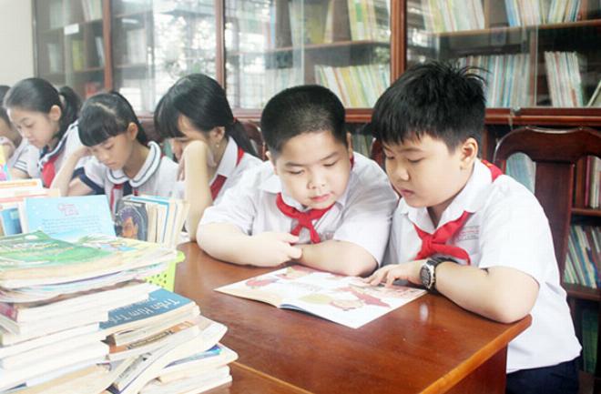Một nhóm học sinh đang cười đùa vui vẻ trong lớp học khi đọc truyện cười ngắn